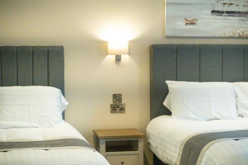 a hotel room with two beds and a side table at The Barmouth Bar & Grill in Barmouth