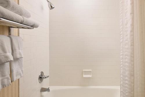 a bathroom with a tub and a shower with towels at Marcus Whitman Hotel and Conference Center in Walla Walla