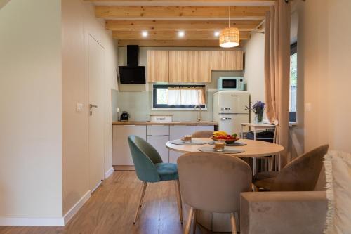 una cucina e una sala da pranzo con tavolo e sedie di Dom boho nad morzem,hot tub,bbq a Kołczewo