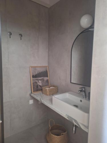 a bathroom with a sink and a mirror at Noma apartment in Gythio