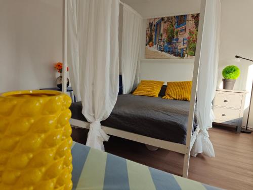 a bedroom with a canopy bed with yellow pillows at Eastern in Tilburg