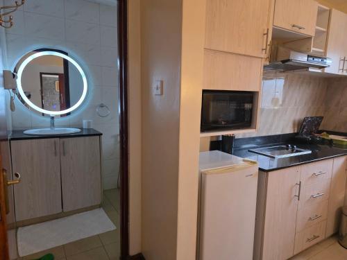 a small kitchen with a sink and a mirror at Nairobi bliss haven in Nairobi
