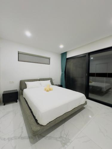 a bedroom with a white bed and a window at Golden Palm Apartment with overlooking view in Port Vila