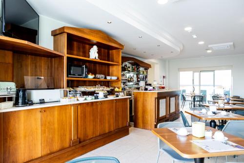 リミニにあるHotel Acquamarina Viserbaの木製のキャビネットとテーブル付きのキッチン