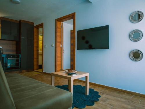 a living room with a table and a flat screen tv at TaNa's Apartments in Donji Štoj