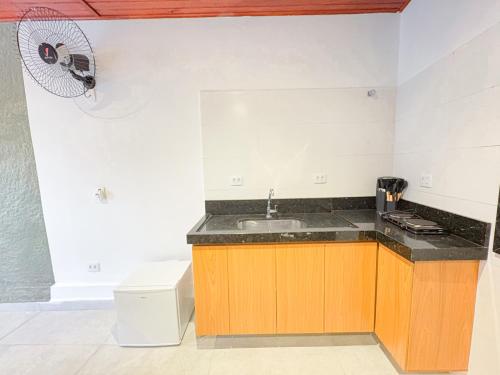 a kitchen with a sink and a stove and a fan at Smart Hotel Reserva Campos do Jordão in Campos do Jordão