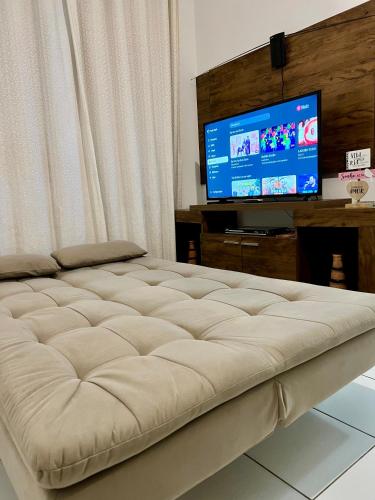 a large bed in a living room with a television at APT Superior CABO BRANCO - Ar condicionado nos 2 quartos - WiFi - Próx a praia de Cabo Branco, a UFPB e ao centro de convenções in João Pessoa