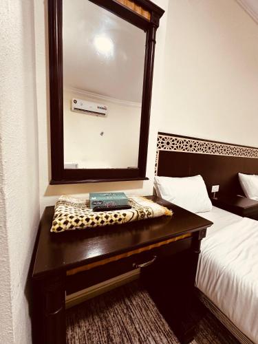 a mirror on a table in a hotel room at ارجوان الصفوة بلازا - arjuan alsafwa in Miná