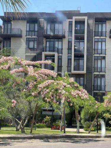 a large apartment building with a flowering tree in front of it at Privado New Cairo in New cairo