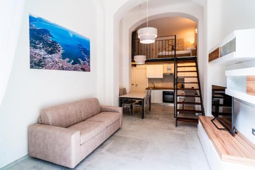 a living room with a couch and a staircase at Way of Loft in La Spezia