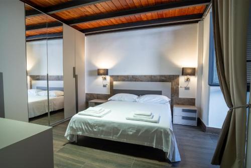 a bedroom with a white bed and a mirror at Way of Loft in La Spezia