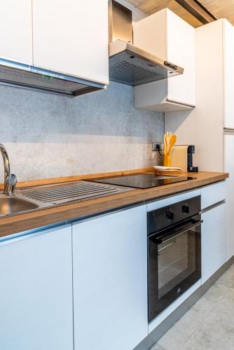a kitchen with white cabinets and a sink at Way of Loft in La Spezia