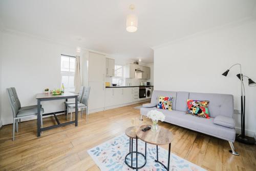 a living room with a couch and a table at Central Woking Retreat - Two-bed flat with parking in Horsell