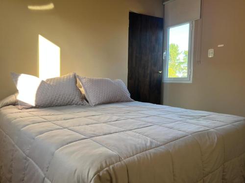 a large bed in a room with a window at Hostería Las Rosas Trevelin in Trevelín