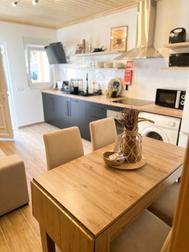 a kitchen with a wooden table with chairs and a kitchen with a counter at Casa Rústica em Loulé - Karmea's Houses in Loulé