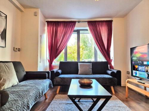 a living room with a couch and a table at Explore London: 2 Bedroom House in Wood Green in London