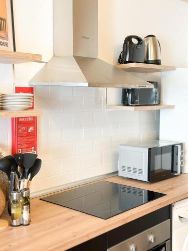 a kitchen with a counter top with a microwave at Casa Rústica em Loulé - Karmea's Houses in Loulé