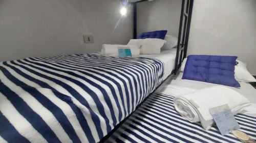 a bedroom with two beds with blue and white stripes at Suites Essepê Quartin! Expo Center Norte, Anhembi, Rodoviaria Tiete, Feira da Madrugada, Brás in Sao Paulo