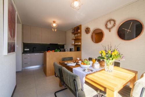 a kitchen and dining room with a wooden table and chairs at VILA DOMOVINA in Tatranská Lomnica