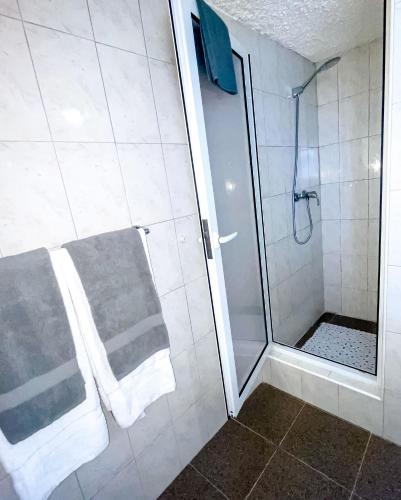a bathroom with a shower with towels and a walk in shower at ValverdeApart in Madalena