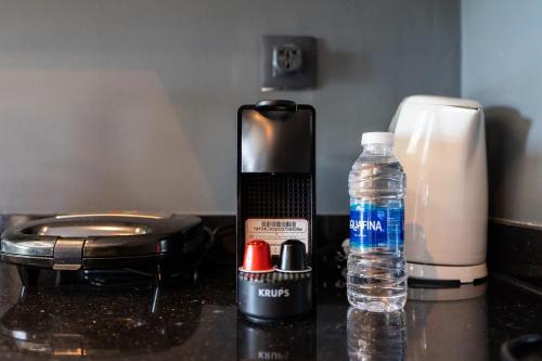 a counter with a bottle of water and a cell phone at Résidence Cerezo in Maarif