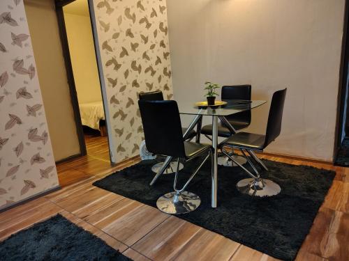 a dining room with a table and four chairs at DEPARTAMENTOs 3D 1BDESAYUNO ESTACIONAMIENTO FACTURA in Chillán