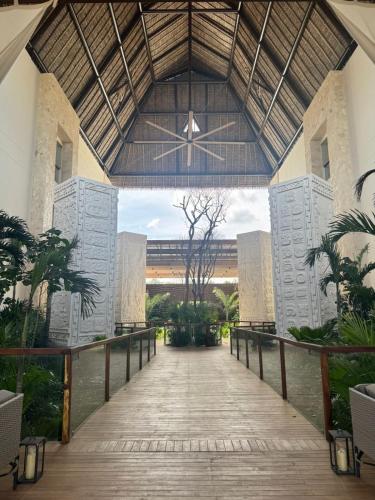 a walkway leading to a building with a large ceiling at Hotel Mundo Maya Tulum in Tulum