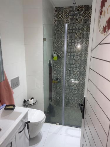 a bathroom with a shower with a toilet and a sink at Le Style in Mehdiya-Plage
