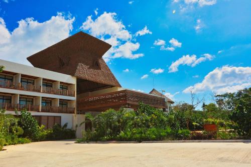 a building with a sculpture on the side of it at Hotel Mundo Maya Tulum in Tulum