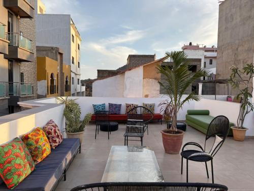 a patio with a couch and chairs on a balcony at La Maison des Couleurs in Dakar