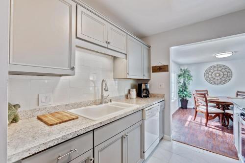 a kitchen with white cabinets and a dining table at Charming West Palm Beach Home in West Palm Beach