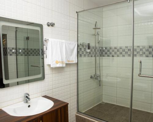 a bathroom with a sink and a glass shower at Mareot Hotel & Spa in Lagos