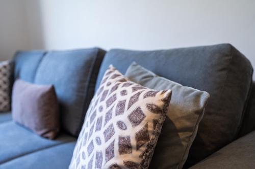 a blue couch with pillows on it at Résidence Cerezo in Maarif