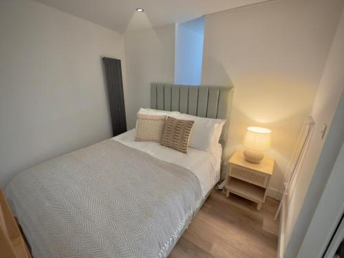 a small bedroom with a bed and a lamp at Wood & Teal Nest in Bradford