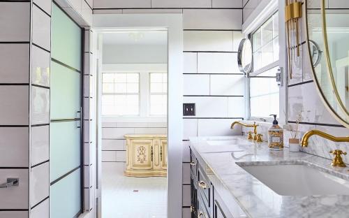 a bathroom with a sink and a mirror at Hollywood Deluxe Homestay in Los Angeles