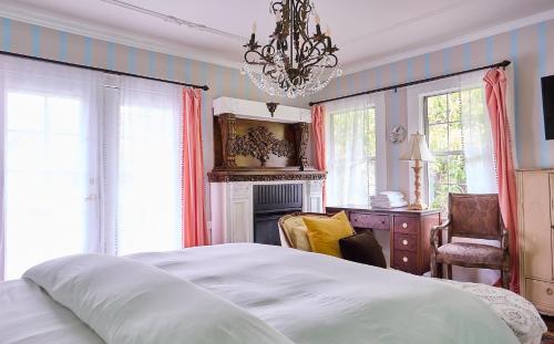 een slaapkamer met een groot bed en een kroonluchter bij Hollywood Deluxe Homestay in Los Angeles