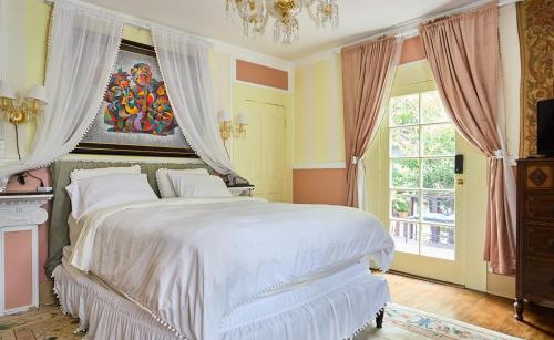 een slaapkamer met een groot wit bed met een kroonluchter bij Hollywood Deluxe Homestay in Los Angeles