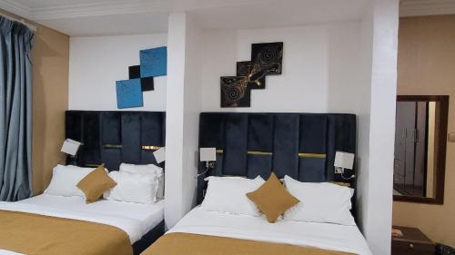 two beds sitting next to each other in a room at Mareot Hotel & Spa in Lagos