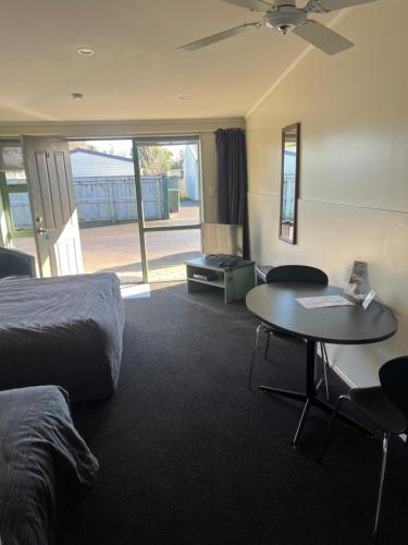 a hotel room with a bed and a table and a desk at A'La Vista Motel in Palmerston North