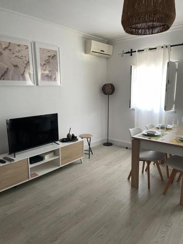 a living room with a flat screen tv and a table at A Casa da Cilarca in Portel
