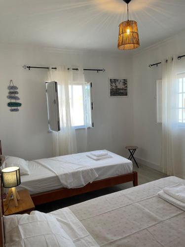 a bedroom with two beds and a chandelier at A Casa da Cilarca in Portel