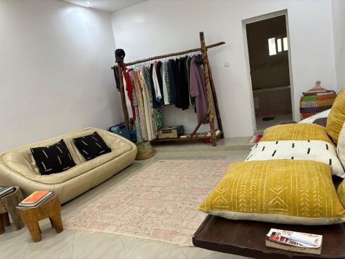 a room with a bed and a couch and a table at La Maison des Couleurs in Dakar