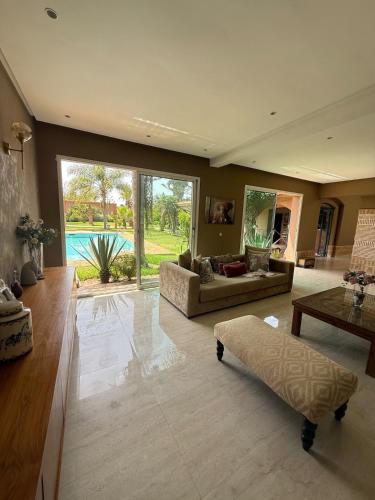 a large living room with a couch and a table at Chic home with a private pool in Dar Mouddene