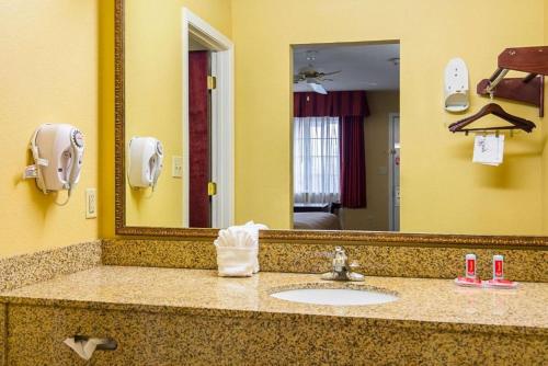 a bathroom with a sink and a mirror at Bryant Inn And Suites in Bryant