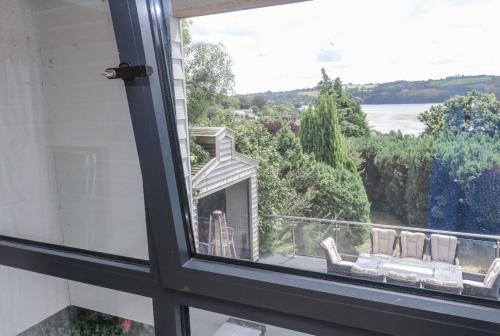 a window with a view of a balcony with a couch at Creek view house in Feock