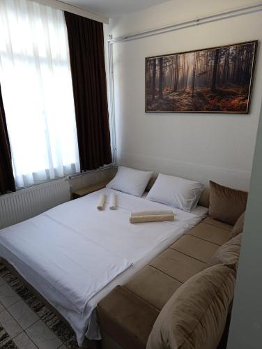 a large bed in a room with a couch at Planić in Prijepolje