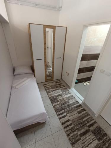 a room with two mirrors and a bed and a rug at Planić in Prijepolje