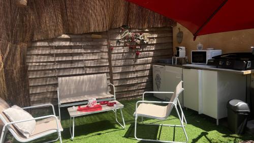 une cuisine avec deux chaises, une table et un comptoir dans l'établissement Bulle insolite avec jacuzzi privé - Nature & romantisme a Fréjus, à Fréjus