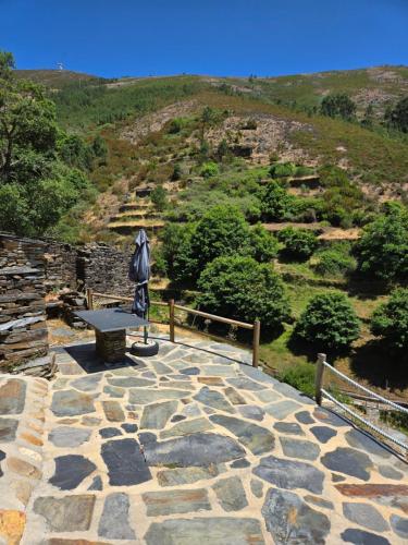 a stone walkway with a bench on top of a hill at Tojo Natur Piodão in Piódão