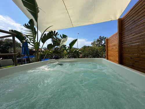 - un bain à remous avec un parasol dans l'arrière-cour dans l'établissement Blue Velvet Rooms, à Tortolì